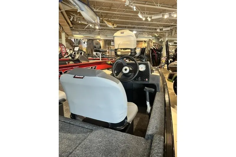 Slide: The Image of 2027 Tracker Bass Tracker Classic XL boat interior with steering wheel and seating in showroom. - 9