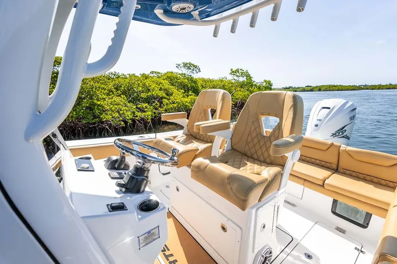 Slide: The Image of Manufacturer Provided Image: 2025 Sportsman Heritage 261 Center Console boat interior with tan seating and steering wheel. - 16
