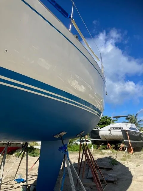 Slide: The Image of A 1979 Nautor Swan 441 on dry dock. The hull is painted blue and white. - 8