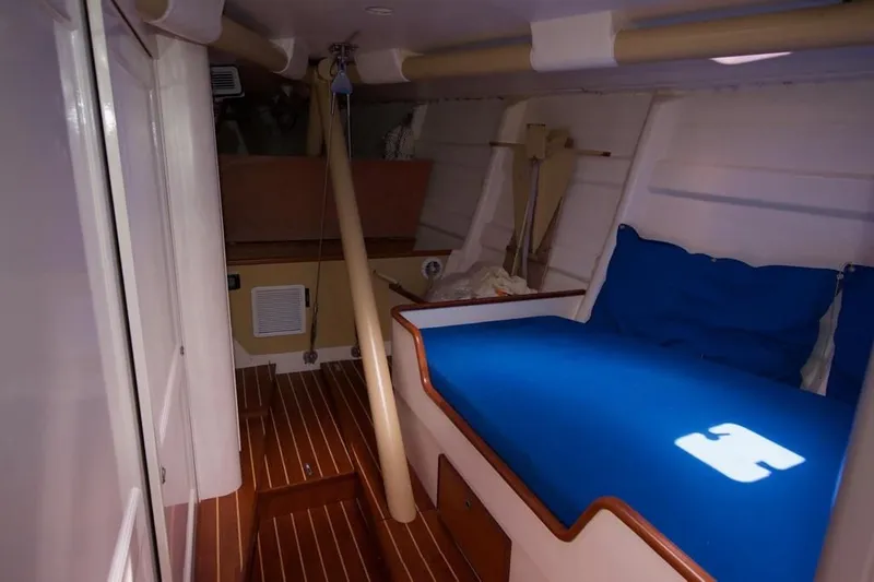 Slide: The Image of Interior of a 1979 Nautor Swan 441 with wooden flooring and blue upholstery. - 13