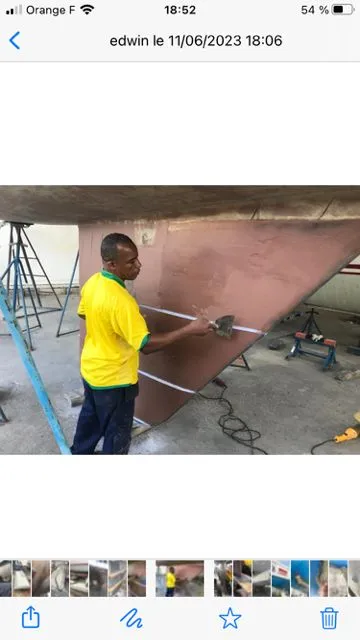 Slide: The Image of A man works on the hull of a 1979 Nautor Swan 441 sailboat in a workshop. - 29
