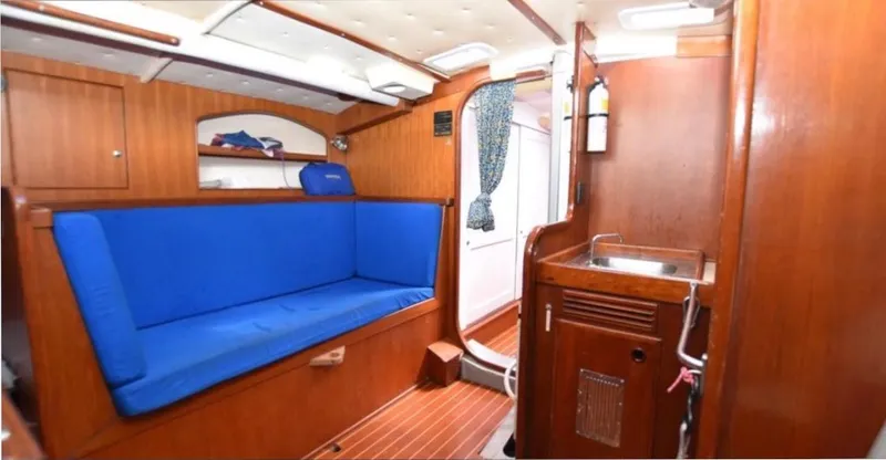 Slide: The Image of Interior of a 1979 Nautor Swan 441 with blue cushions and wooden fittings. - 11