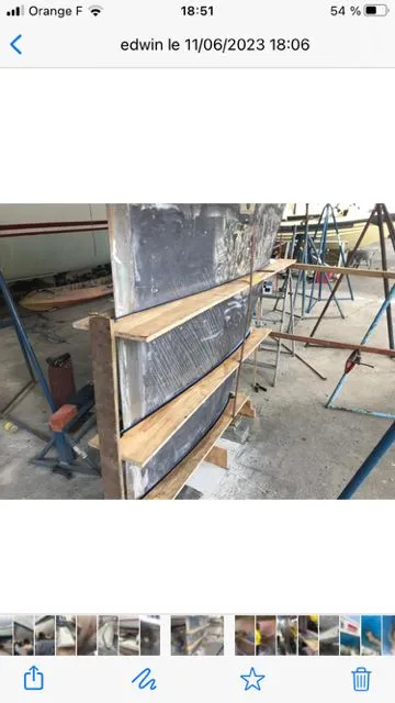 Slide: The Image of A 1979 Nautor Swan 441 undergoing repairs in a workshop. Wooden planks support the hull. - 28