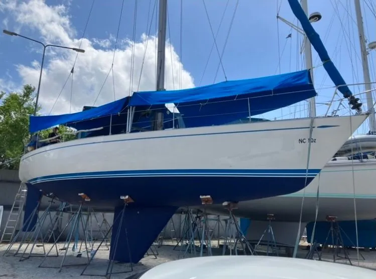 Slide: The Image of A 1979 Nautor Swan 441 is on a dry dock, surrounded by other boats. - 5