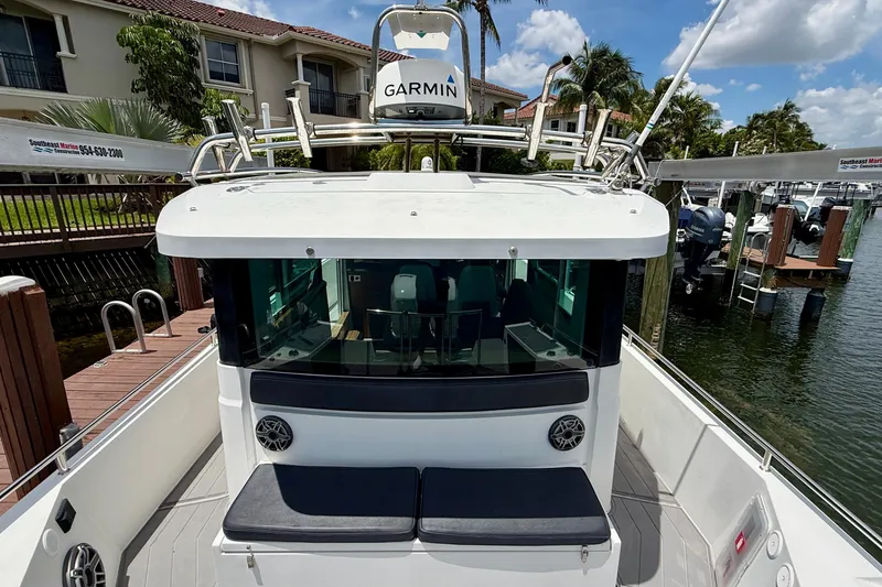 Slide: The Image of 2018 Axopar 37 Sports Cabin docked, featuring Garmin equipment and spacious seating area. - 15