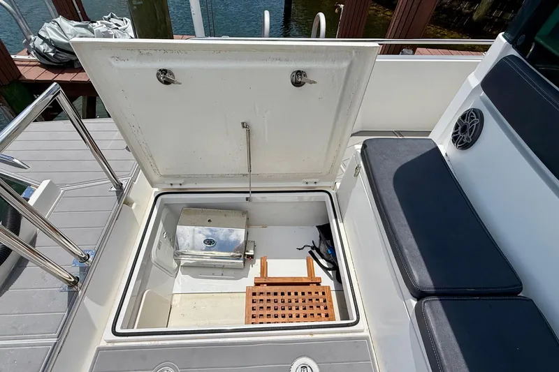 Slide: The Image of Open storage compartment on 2018 Axopar 37 Sports Cabin boat, featuring seating and equipment. - 20