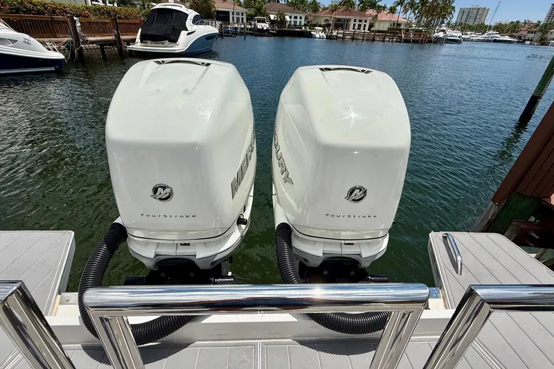 Slide: The Image of Twin Mercury outboard engines on a 2018 Axopar 37 Sports Cabin boat docked by the water. - 12