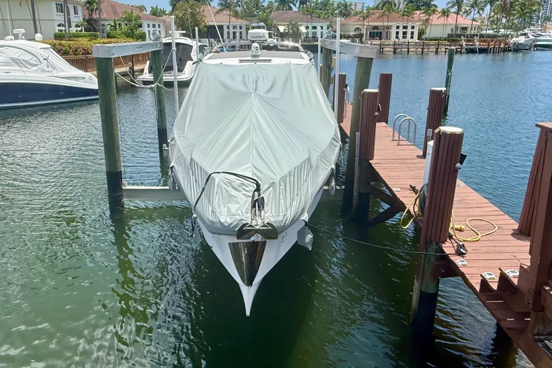 Slide: The Image of 2018 Axopar 37 Sports Cabin boat covered and docked at a marina. - 48