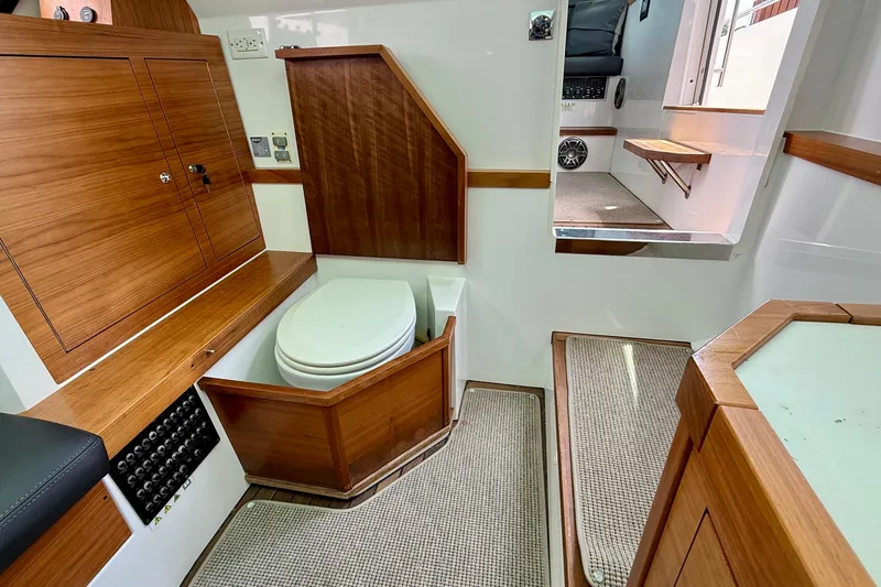 Slide: The Image of 2018 Axopar 37 Sports Cabin interior with wooden cabinetry and compact toilet. - 46