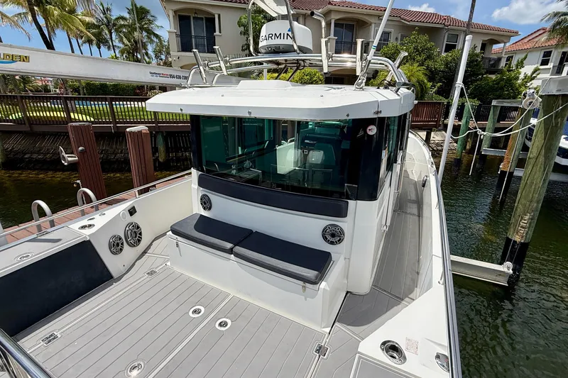 Slide: The Image of 2018 Axopar 37 Sports Cabin docked, featuring sleek design and spacious deck area. - 16