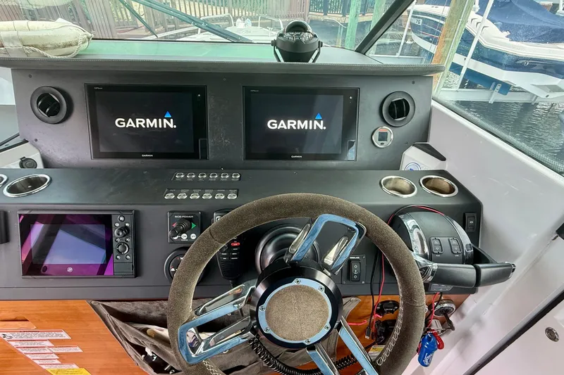 Slide: The Image of Cockpit of 2018 Axopar 37 Sports Cabin with Garmin navigation displays and steering wheel. - 38