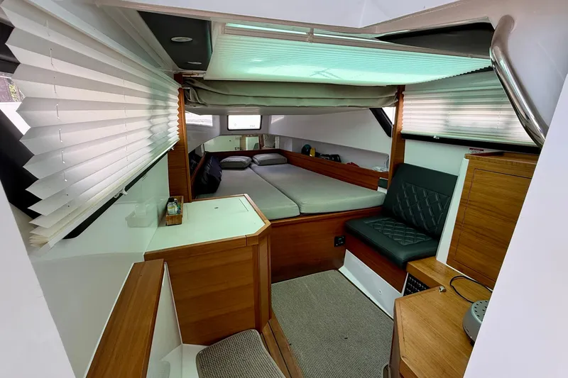 Slide: The Image of 2018 Axopar 37 Sports Cabin interior with cozy bed, seating, and wooden cabinetry. - 44
