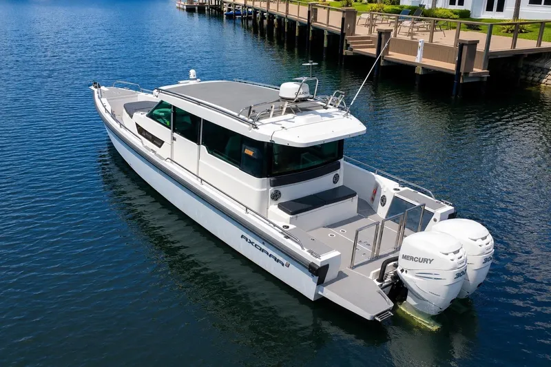 Slide: The Image of 2018 Axopar 37 Sports Cabin boat with twin Mercury engines on calm water. - 4