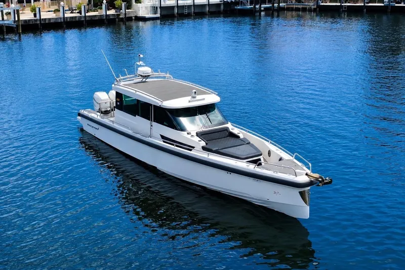 Slide: The Image of 2018 Axopar 37 Sports Cabin boat on calm blue water. - 10