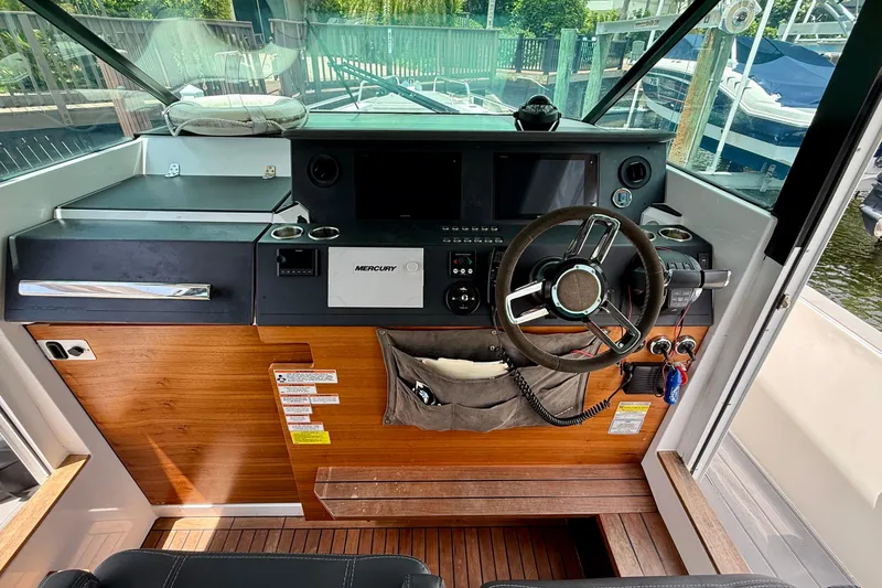 Slide: The Image of 2018 Axopar 37 Sports Cabin helm with steering wheel and control panel. - 36