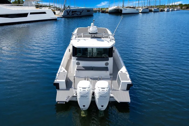 Slide: The Image of 2018 Axopar 37 Sports Cabin boat docked in a marina with twin engines. - 6