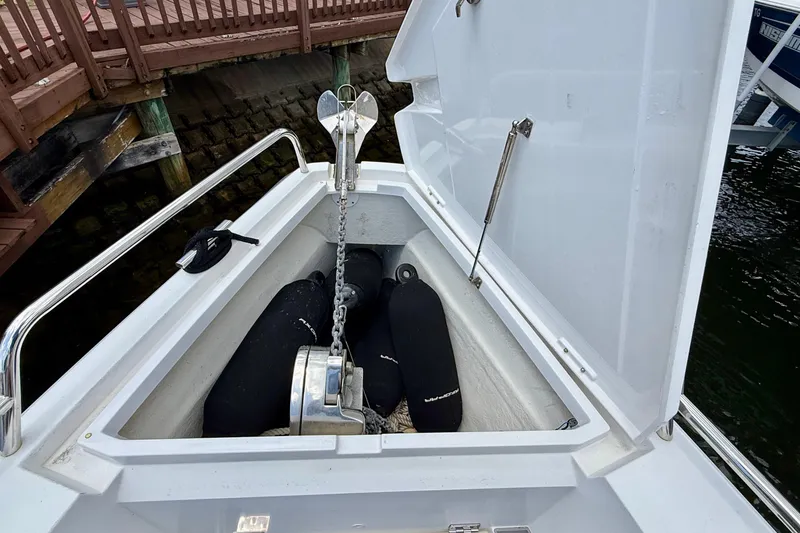 Slide: The Image of Anchor compartment of 2018 Axopar 37 Sports Cabin boat, featuring chain and fenders. - 32
