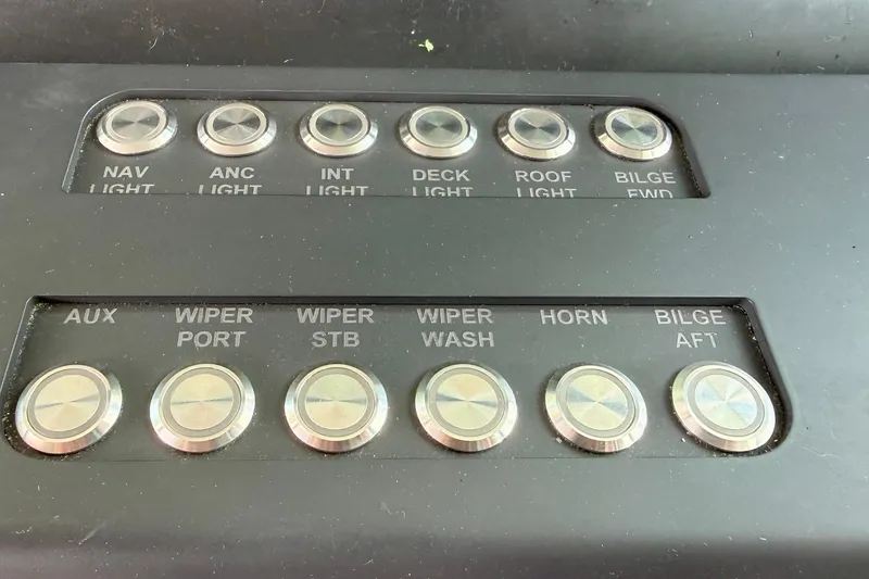 Slide: The Image of Control panel of a 2018 Axopar 37 Sports Cabin with labeled buttons for lights and wipers. - 40