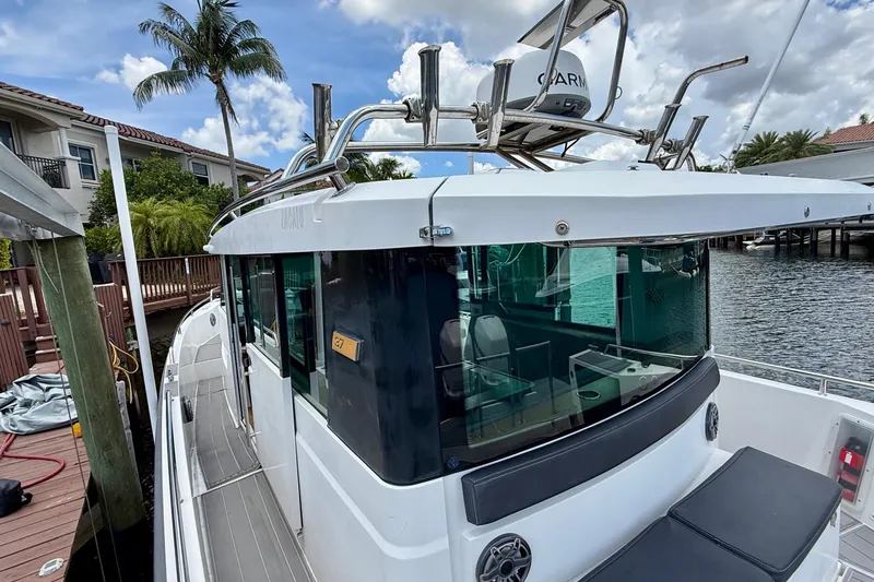 Slide: The Image of 2018 Axopar 37 Sports Cabin docked by waterfront homes under a blue sky. - 24