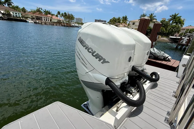 Slide: The Image of Twin Mercury outboard engines on a 2018 Axopar 37 Sports Cabin, docked by waterfront homes. - 11