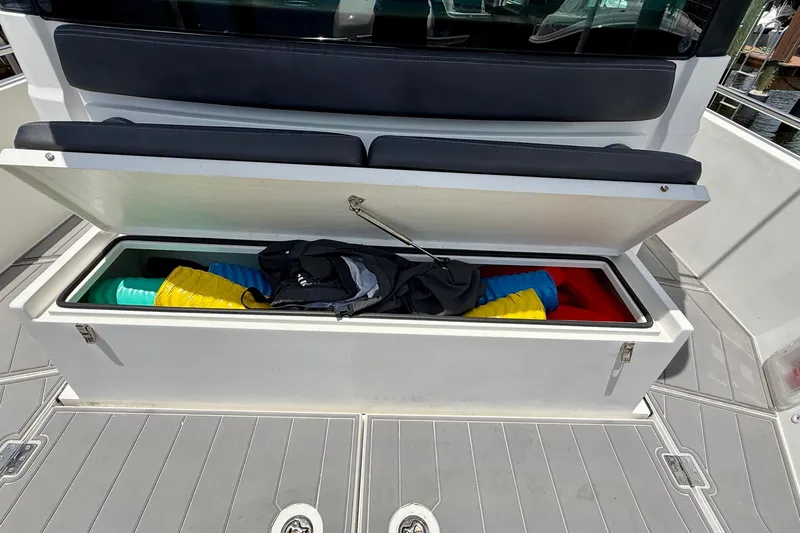 Slide: The Image of Storage compartment on 2018 Axopar 37 Sports Cabin boat, containing colorful items and gear. - 19