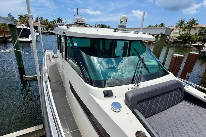 Slide: The Image of 2018 Axopar 37 Sports Cabin docked, featuring sleek design and spacious deck. - 29