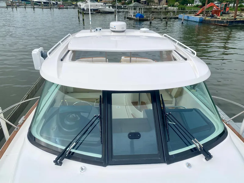 Slide: The Image of The 2012 Tiara Yachts 3100 Coronet is docked on the water. It features a sleek design with large windows. - 17