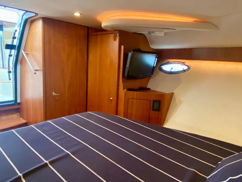 Slide: The Image of The cabin of the 2012 Tiara Yachts 3100 Coronet features an elegant interior with a striped bed. - 25