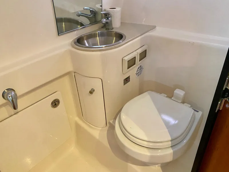 Slide: The Image of The image shows a clean, modern boat bathroom with a sink and toilet. - 27