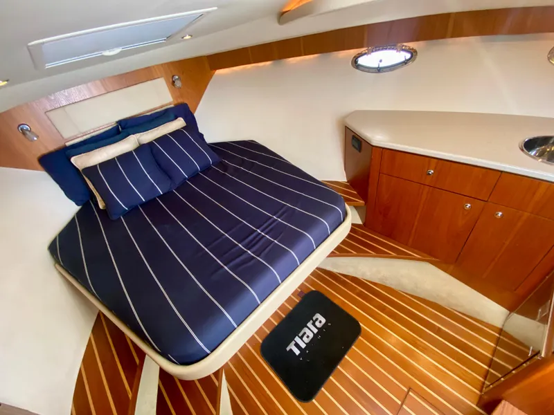 Slide: The Image of The 2012 Tiara Yachts 3100 Coronet cabin features a cozy bed and wooden cabinetry. - 22