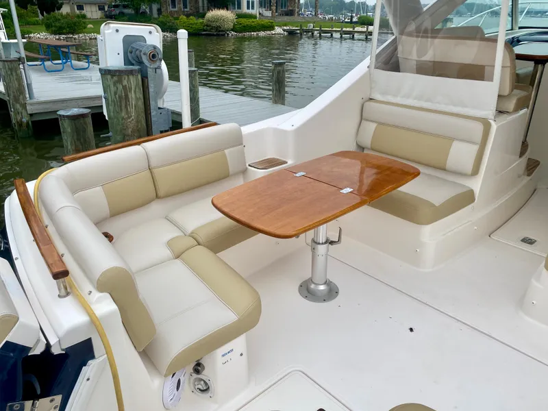 Slide: The Image of The image shows the cockpit of a 2012 Tiara Yachts 3100 Coronet with beige seating and a wooden table. - 10