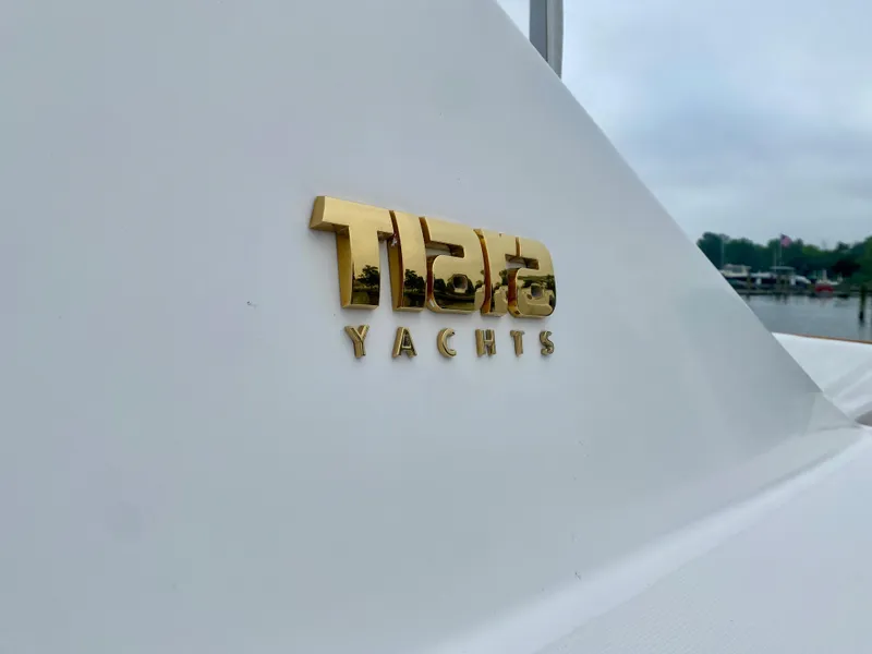 Slide: The Image of Close-up of the gold Tiara Yachts logo on a white boat. - 6