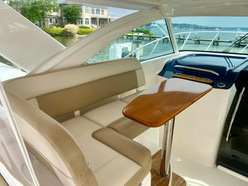 Slide: The Image of Interior of a 2012 Tiara Yachts 3100 Coronet with beige seating area and wooden table. - 13
