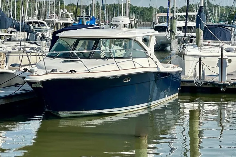 Slide: The Image of 2012 Tiara Yachts 3100 Coronet docked at marina with other boats. - 3