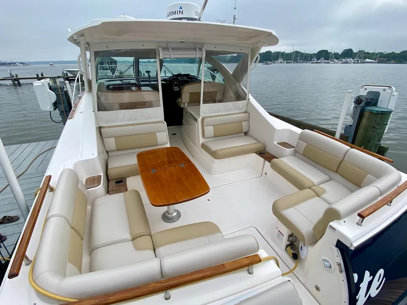 Slide: The Image of The image shows a 2012 Tiara Yachts 3100 Coronet with beige seating and a wooden table. - 8