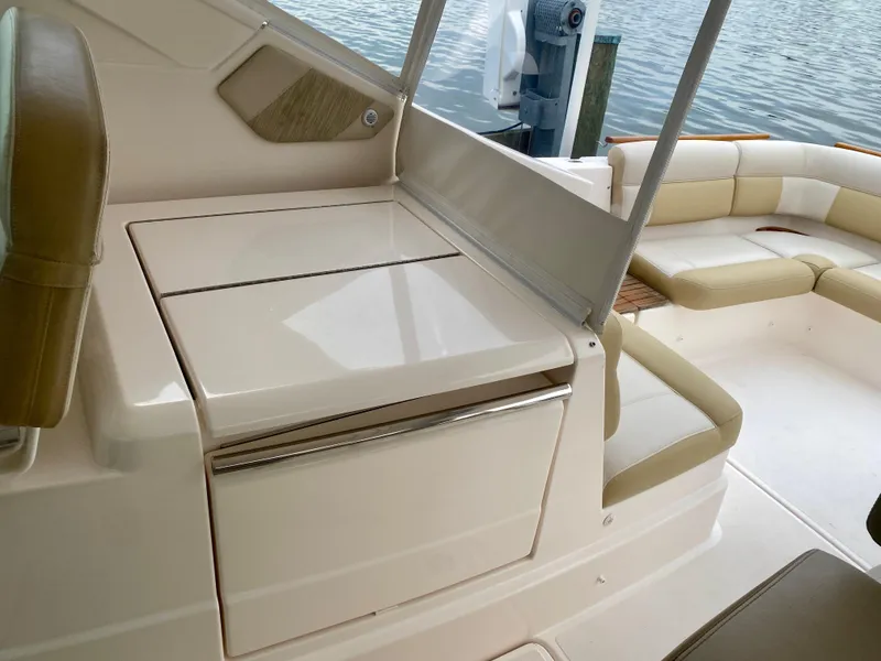 Slide: The Image of The 2012 Tiara Yachts 3100 Coronet features an elegant seating area with beige upholstery and a table. - 16