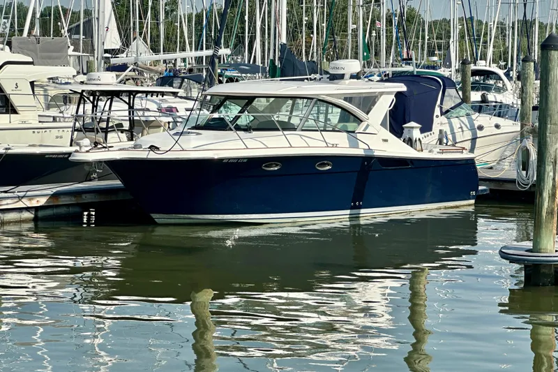 Slide: The Image of 2012 Tiara Yachts 3100 Coronet docked in a marina, surrounded by other boats. - 4