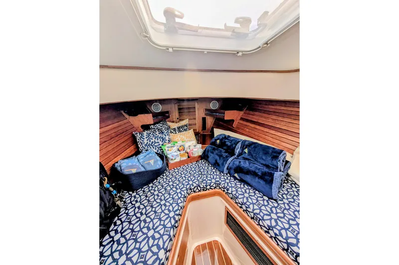 Slide: The Image of Interior of 2003 Hinckley Picnic Boat 36 EP with cozy bedding and nautical decor. - 36