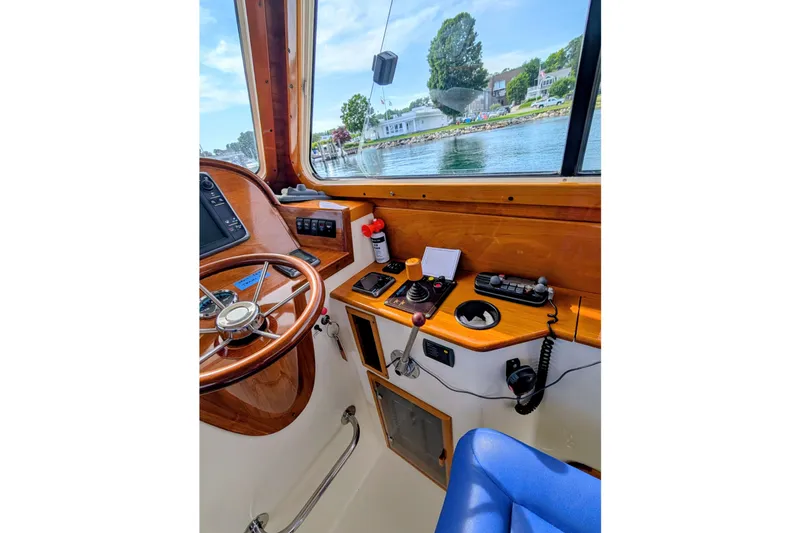 Slide: The Image of Interior helm of 2003 Hinckley Picnic Boat 36 EP with wooden steering wheel and controls. - 28