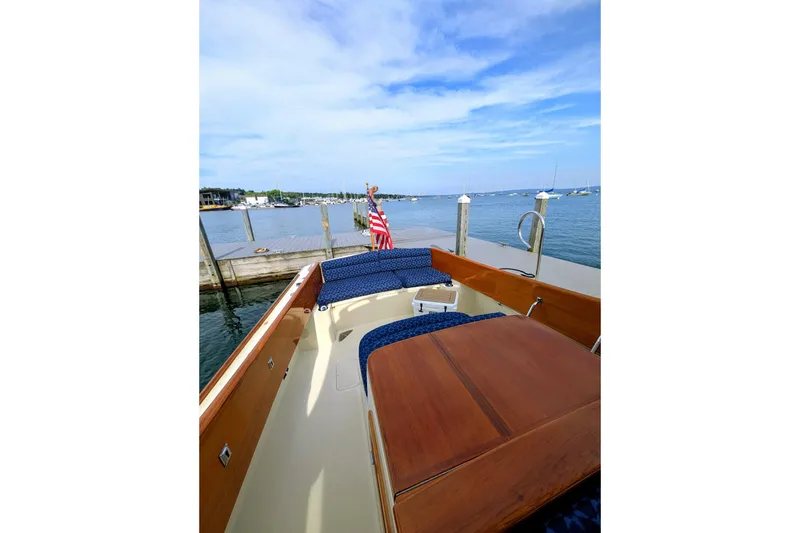 Slide: The Image of 2003 Hinckley Picnic Boat 36 EP docked, showcasing elegant wooden deck and seating. - 18