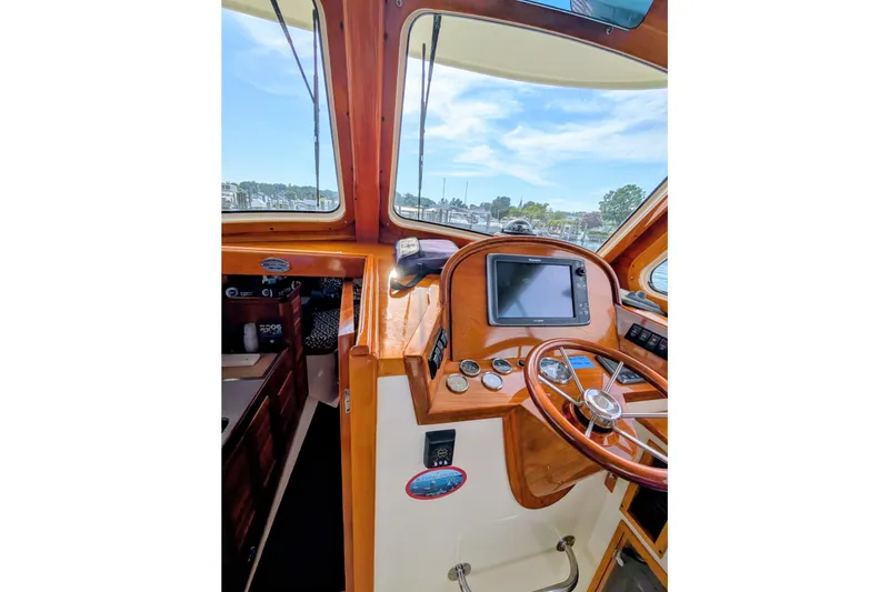 Slide: The Image of 2003 Hinckley Picnic Boat 36 EP helm with wooden steering wheel and navigation display. - 32