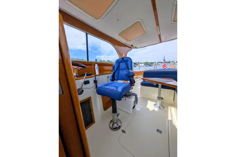 Slide: The Image of Interior of 2003 Hinckley Picnic Boat 36 EP with blue captain's chair and wooden accents. - 26