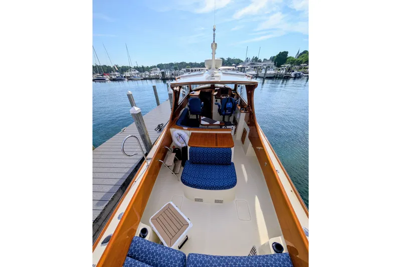 Slide: The Image of 2003 Hinckley Picnic Boat 36 EP docked, showcasing elegant seating and polished wood finish. - 17