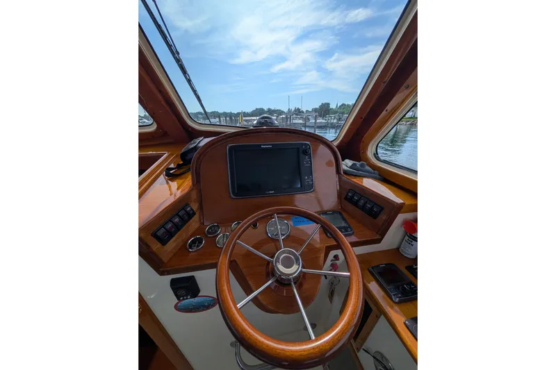 Slide: The Image of Helm of 2003 Hinckley Picnic Boat 36 EP with wooden steering wheel and navigation equipment. - 27