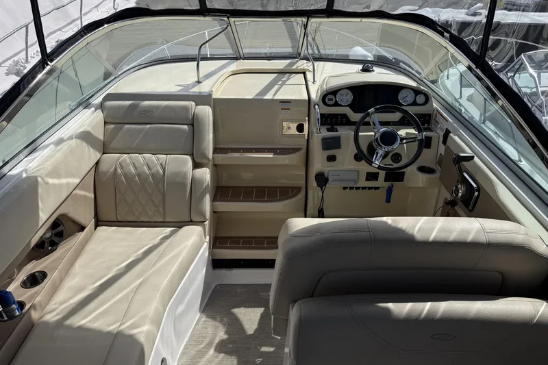 Slide: The Image of 2019 Regal 28 Express boat interior with beige seating and modern dashboard controls. - 8