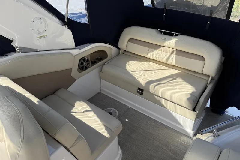 Slide: The Image of 2019 Regal 28 Express boat interior with beige seating and dark blue canopy. - 7