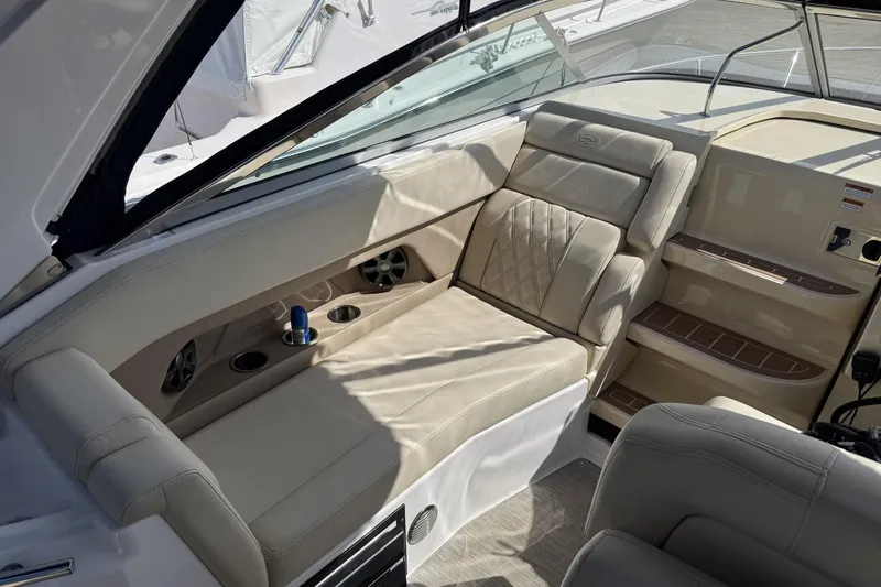 Slide: The Image of 2019 Regal 28 Express boat interior with beige seating and cup holders. - 9