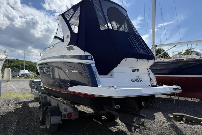 Slide: The Image of 2019 Regal 28 Express boat on trailer under a cloudy sky. - 4