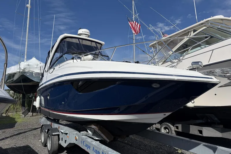 Slide: The Image of 2019 Regal 28 Express boat on trailer, surrounded by other boats, under clear blue sky. - 2