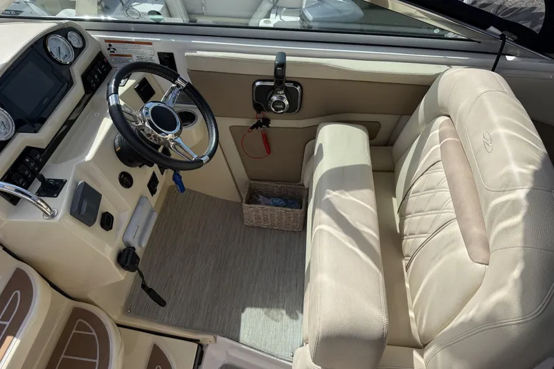 Slide: The Image of Interior of a 2019 Regal 28 Express boat with steering wheel and beige seating. - 10